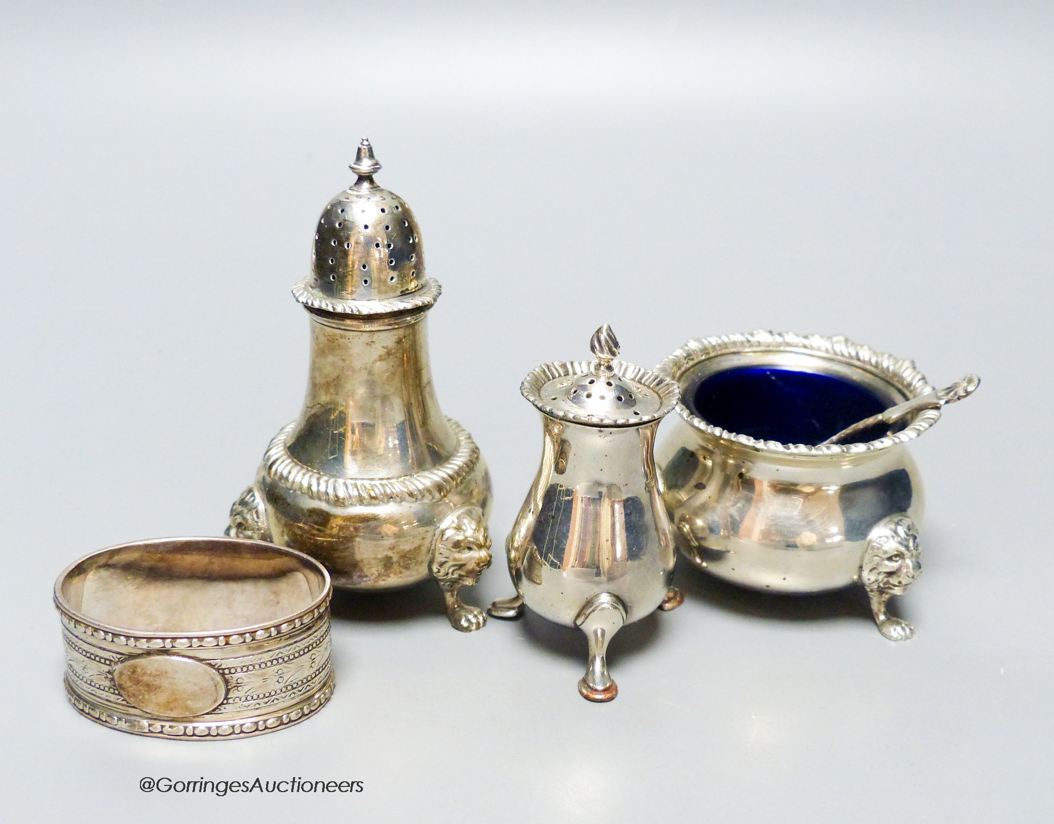 Two silver condiments by Harrods, one similar silver condiment, a silver spoon and a plated napkin ring.